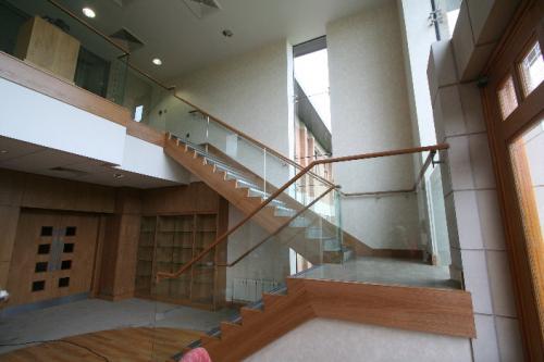 wooden staircase with glass balustrade