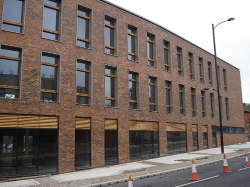 large brick building with wooden cladding surrounding windows