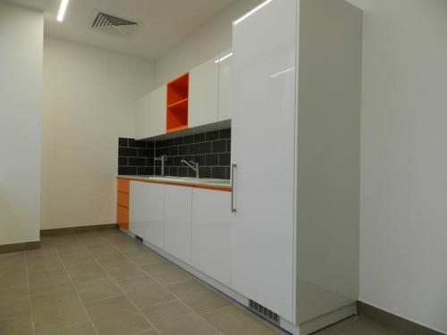 white kitchen area with orange accents