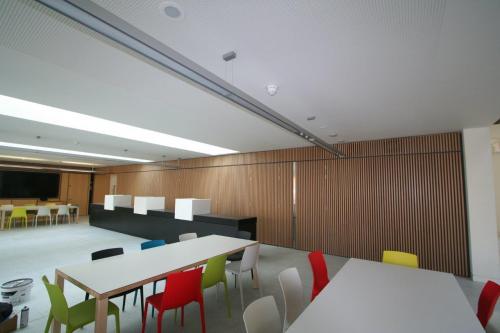 wooden cladding on wall and tables with coloured chairs