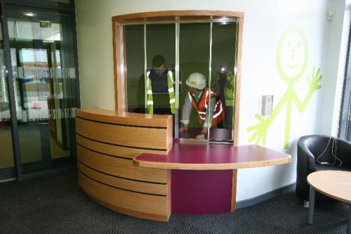 curved wood and pink reception desk